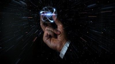 Scientist holding atom particle between his fingers GETTY